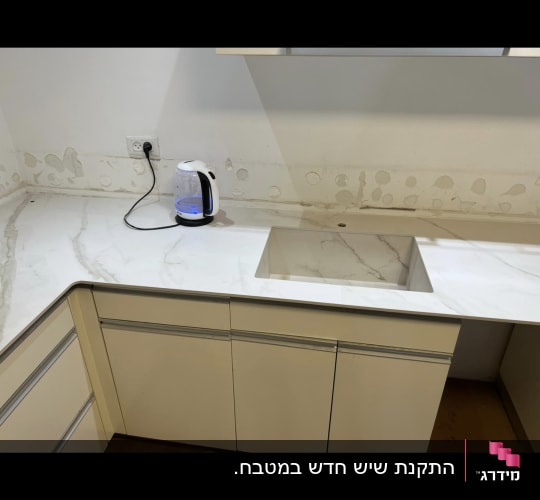 משטח שיש לבן עם כיור מובנה במטבח